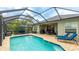 A screened pool with an outdoor patio is furnished with a seating set, grill, and lounge chairs at 3839 Autumn Fern Ter, Sarasota, FL 34243