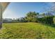 Expansive backyard with lush green grass and mature trees, backing up to a tranquil pond at 4414 Turnberry Ct, Bradenton, FL 34210