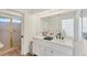 Bright bathroom with double sinks, sleek vanity, and a glass-enclosed shower at 4414 Turnberry Ct, Bradenton, FL 34210