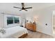 Bright bedroom features a wooden dresser, floor mirror, ceiling fan, and an exterior view through the window at 4414 Turnberry Ct, Bradenton, FL 34210
