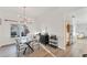 Elegant dining room with modern chandelier, glass table, and seamless flow into a bright kitchen with stainless appliances at 4414 Turnberry Ct, Bradenton, FL 34210