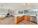 Open concept kitchen with stainless appliances, custom wood cabinets, and breakfast bar connects to the living room at 4414 Turnberry Ct, Bradenton, FL 34210