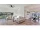 Open-concept living and dining room with modern decor, light wood flooring, and ample natural light from large windows at 4414 Turnberry Ct, Bradenton, FL 34210