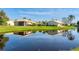 Scenic pond reflecting the surrounding homes and clear blue sky, creating a tranquil waterfront setting at 4414 Turnberry Ct, Bradenton, FL 34210