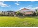 A well-maintained backyard featuring lush grass, manicured bushes, and a screened-in lanai at 534 Warwick Ln, Venice, FL 34293