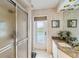 Bathroom featuring a glass-enclosed shower, granite countertop, and a window for natural light at 534 Warwick Ln, Venice, FL 34293