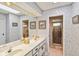 Bathroom featuring a double sink vanity, wallpaper and multiple mirrors at 534 Warwick Ln, Venice, FL 34293