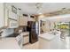 Well-lit kitchen with stainless steel appliances, white cabinetry, and a breakfast bar island with sink at 534 Warwick Ln, Venice, FL 34293