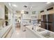 Open kitchen with breakfast bar and stainless appliances with breakfast table in the background at 534 Warwick Ln, Venice, FL 34293