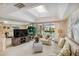 Bright living room featuring a skylight, neutral carpet, and sliding glass doors to the pool at 534 Warwick Ln, Venice, FL 34293