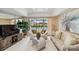 Bright living room featuring a skylight, neutral carpet, and sliding glass doors to the pool at 534 Warwick Ln, Venice, FL 34293