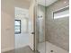 Modern bathroom featuring a glass shower with gray marble walls, and views of the water at 552 Bocelli Dr, North Venice, FL 34275