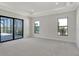 Spacious main bedroom with tray ceiling, carpet, and a sliding glass door to the outdoor living area at 552 Bocelli Dr, North Venice, FL 34275