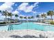Beautiful community pool with palm trees, lounge chairs, and cabanas at 552 Bocelli Dr, North Venice, FL 34275