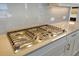 Close-up of a stainless steel gas cooktop with multiple burners and stylish control knobs at 552 Bocelli Dr, North Venice, FL 34275
