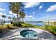 Inviting community hot tub overlooking a tranquil lake, surrounded by lush landscaping and palm trees at 552 Bocelli Dr, North Venice, FL 34275