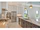 Modern kitchen featuring stainless steel appliances, a large island with a quartz countertop, and pendant lighting at 552 Bocelli Dr, North Venice, FL 34275