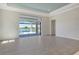 Open-concept living room features tile flooring, a tray ceiling, and sliding doors to an outdoor pool at 552 Bocelli Dr, North Venice, FL 34275