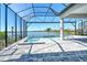 Lake view from this home's beautiful screened pool featuring brick pavers and jacuzzi at 552 Bocelli Dr, North Venice, FL 34275