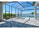 Screened in pool area featuring brick pavers, lake view and an attached jacuzzi at 552 Bocelli Dr, North Venice, FL 34275