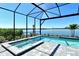 Screened in pool with brick pavers featuring an attached jacuzzi overlooking the lake at 552 Bocelli Dr, North Venice, FL 34275