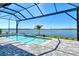 Lake view from this home's stunning pool enclosed with a screen and brick pavers at 552 Bocelli Dr, North Venice, FL 34275