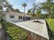 The backyard stone patio is complemented by mature palm trees and manicured landscaping at 5708 Garden Lakes Fern, Bradenton, FL 34203