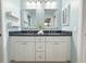 Bathroom with dual sinks, granite countertops, and white cabinetry providing both elegance and functionality at 5708 Garden Lakes Fern, Bradenton, FL 34203