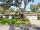 Inviting home with lush landscaping, a driveway leading to a two-car garage, and a classic tile roof at 5708 Garden Lakes Fern, Bradenton, FL 34203