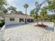 This home has a backyard stone patio featuring mature palms and lush landscaping at 5708 Garden Lakes Fern, Bradenton, FL 34203