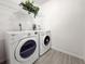 Bright laundry room featuring a Whirlpool washer and dryer, plus wire shelving and stylish, durable tile flooring at 5708 Garden Lakes Fern, Bradenton, FL 34203