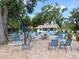 Community pool area with tables, chairs, shade trees, a lifeguard station, and a view of the sparkling pool at 5708 Garden Lakes Fern, Bradenton, FL 34203