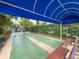 Outdoor shuffleboard court featuring a canopy, benches, manicured landscaping, and a chain-link fence at 5708 Garden Lakes Fern, Bradenton, FL 34203