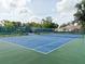 Outdoor community tennis court surrounded by lush landscaping and fencing, with a glimpse of nearby homes at 5708 Garden Lakes Fern, Bradenton, FL 34203
