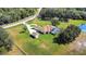Aerial view showcasing a large estate, circular driveway, detached garage, screened pool, and pond at 5750 Saddle Oak Trl, Sarasota, FL 34241