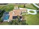 Aerial view of home with solar panels, screened pool, circular drive, and detached garage at 5750 Saddle Oak Trl, Sarasota, FL 34241