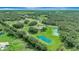 A sprawling estate with large ponds and surrounding greenery, captured from above at 5750 Saddle Oak Trl, Sarasota, FL 34241