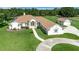 Beautiful aerial view of a home with a lush green lawn, circular driveway, and white exterior at 5750 Saddle Oak Trl, Sarasota, FL 34241