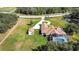 Aerial view showcasing a large estate, circular driveway, detached garage, screened pool, and pond at 5750 Saddle Oak Trl, Sarasota, FL 34241