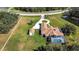 Aerial view showcasing a large estate, circular driveway, detached garage, screened pool, and pond at 5750 Saddle Oak Trl, Sarasota, FL 34241