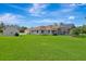 Expansive backyard features a large lawn, pool with screened enclosure, and detached garage at 5750 Saddle Oak Trl, Sarasota, FL 34241