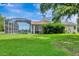 Expansive backyard featuring a screened-in pool and patio area with lush green grass at 5750 Saddle Oak Trl, Sarasota, FL 34241