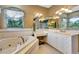 Bathroom features a jacuzzi tub, vanity and a large mirror with vanity lighting at 5750 Saddle Oak Trl, Sarasota, FL 34241