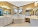 Bathroom featuring dual vanities, a soaking tub, and large mirrors creating a bright and spacious feel at 5750 Saddle Oak Trl, Sarasota, FL 34241