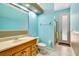 Bathroom with a vanity, toilet, and walk-in shower featuring blue accent wall at 5750 Saddle Oak Trl, Sarasota, FL 34241
