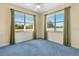 Light-filled bedroom with blue carpet features dual windows and ample natural light at 5750 Saddle Oak Trl, Sarasota, FL 34241