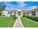 Charming single-story home featuring manicured lawn and a brick pathway leading to the entrance at 5750 Saddle Oak Trl, Sarasota, FL 34241