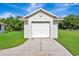 Detached single-car garage features an overhead door and lush green landscaping at 5750 Saddle Oak Trl, Sarasota, FL 34241