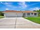 Spacious three-car garage with a concrete driveway and manicured lawn at 5750 Saddle Oak Trl, Sarasota, FL 34241