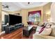 Stylish living room showcasing a large television, comfortable sectional, and hardwood floors at 5750 Saddle Oak Trl, Sarasota, FL 34241